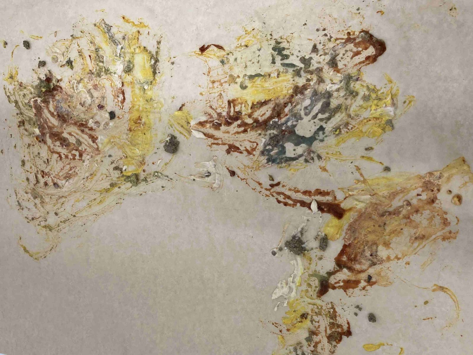 Marks of yellow, brown and grey edible paint left on paper