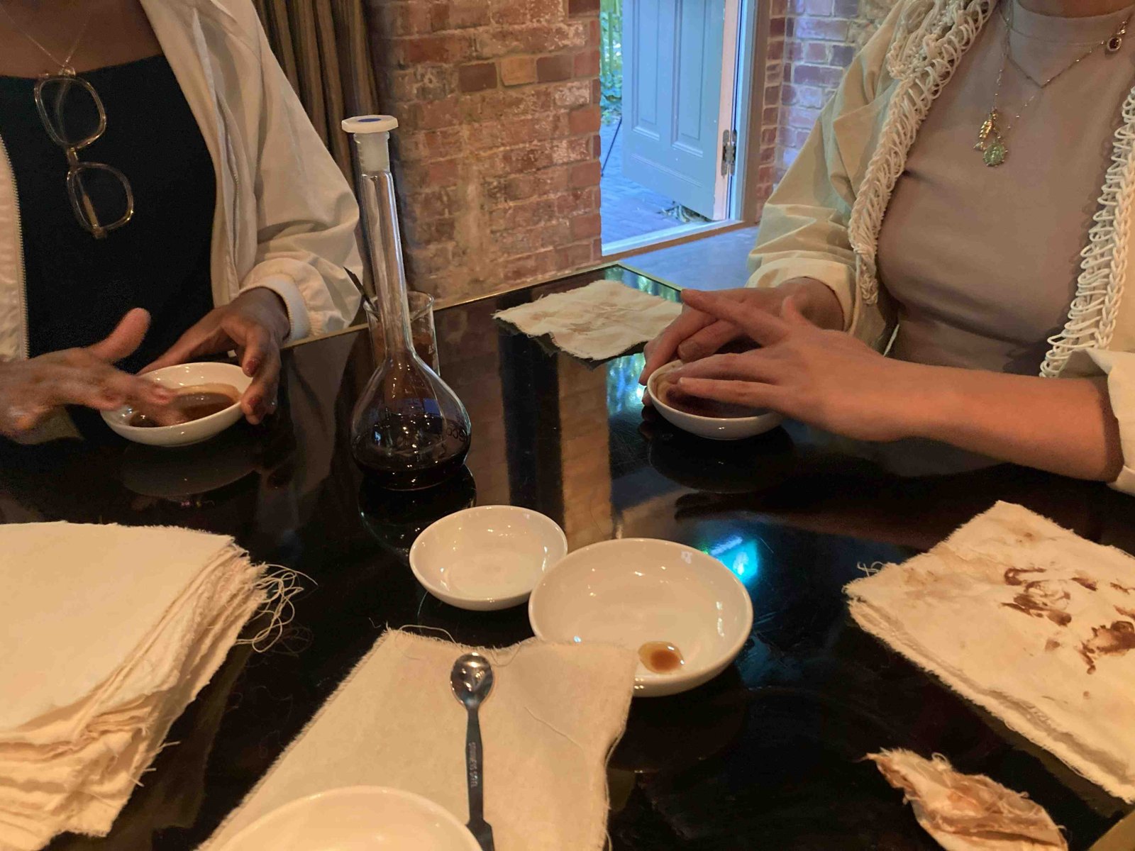 Two visitors at a black table with small bowls and cloth napkins