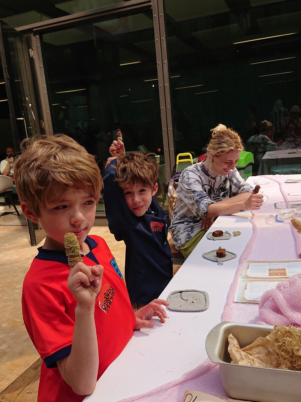 Children holding up finger hats made of celery at the table